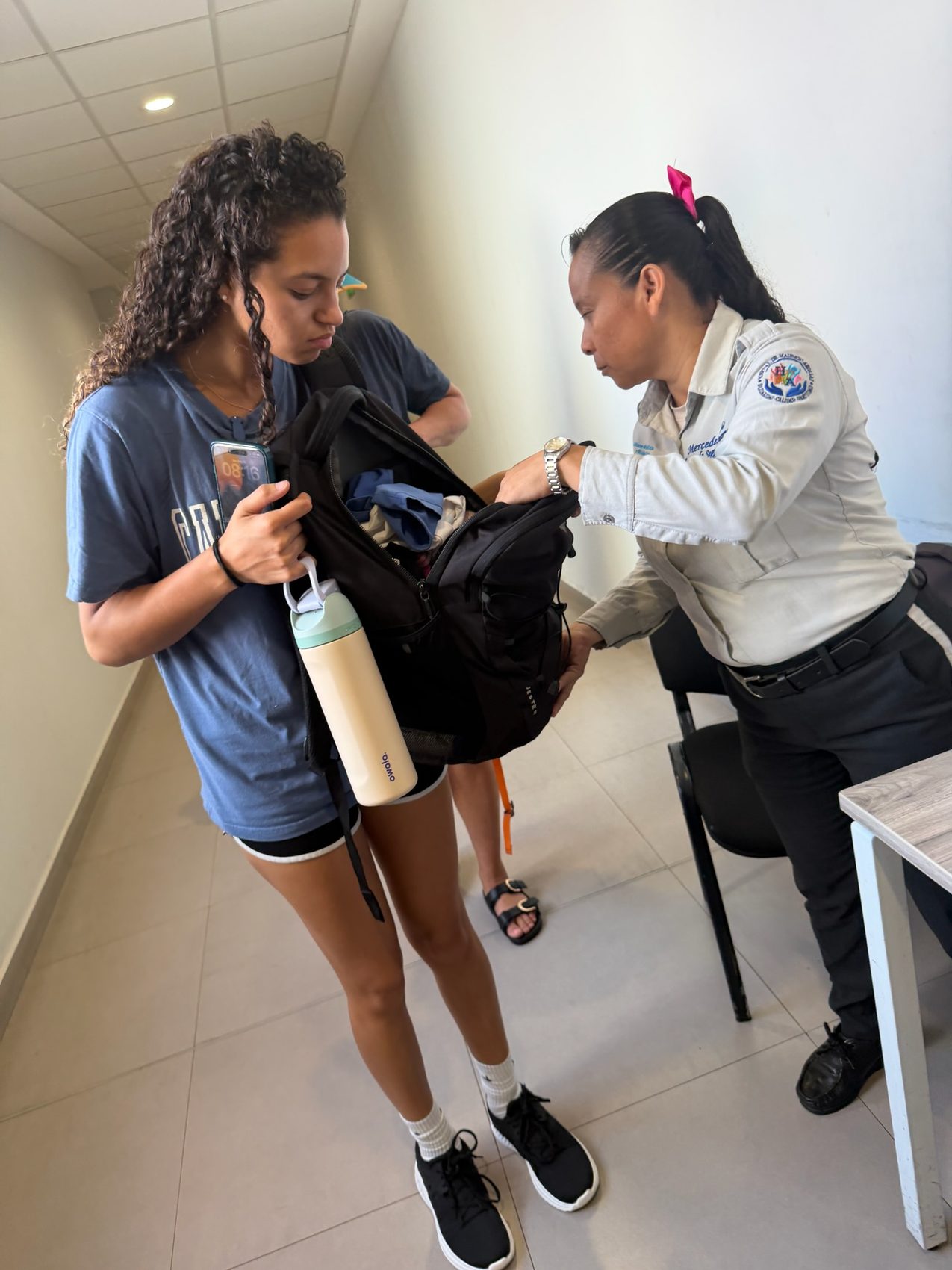 A team member’s backpack being inspected by an official on arrival