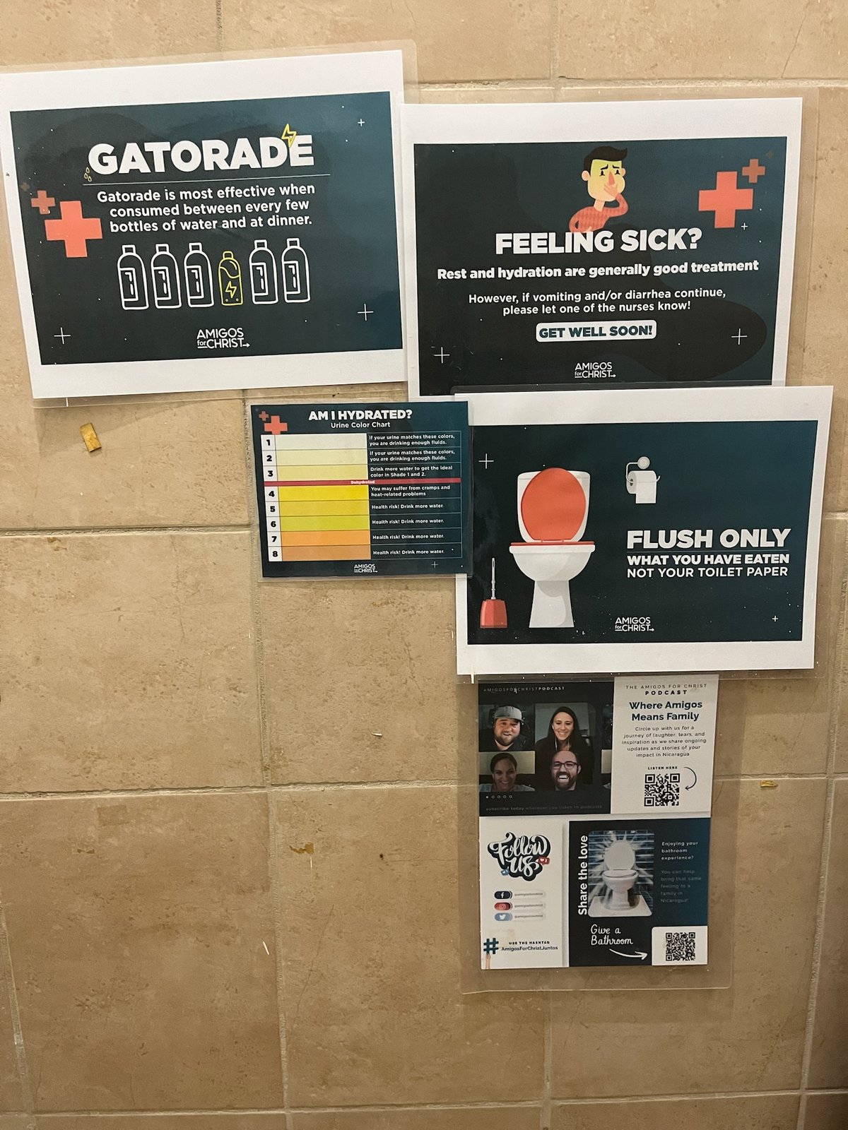 Amigos for Christ bathroom posters on hydration, illness, and toilet paper