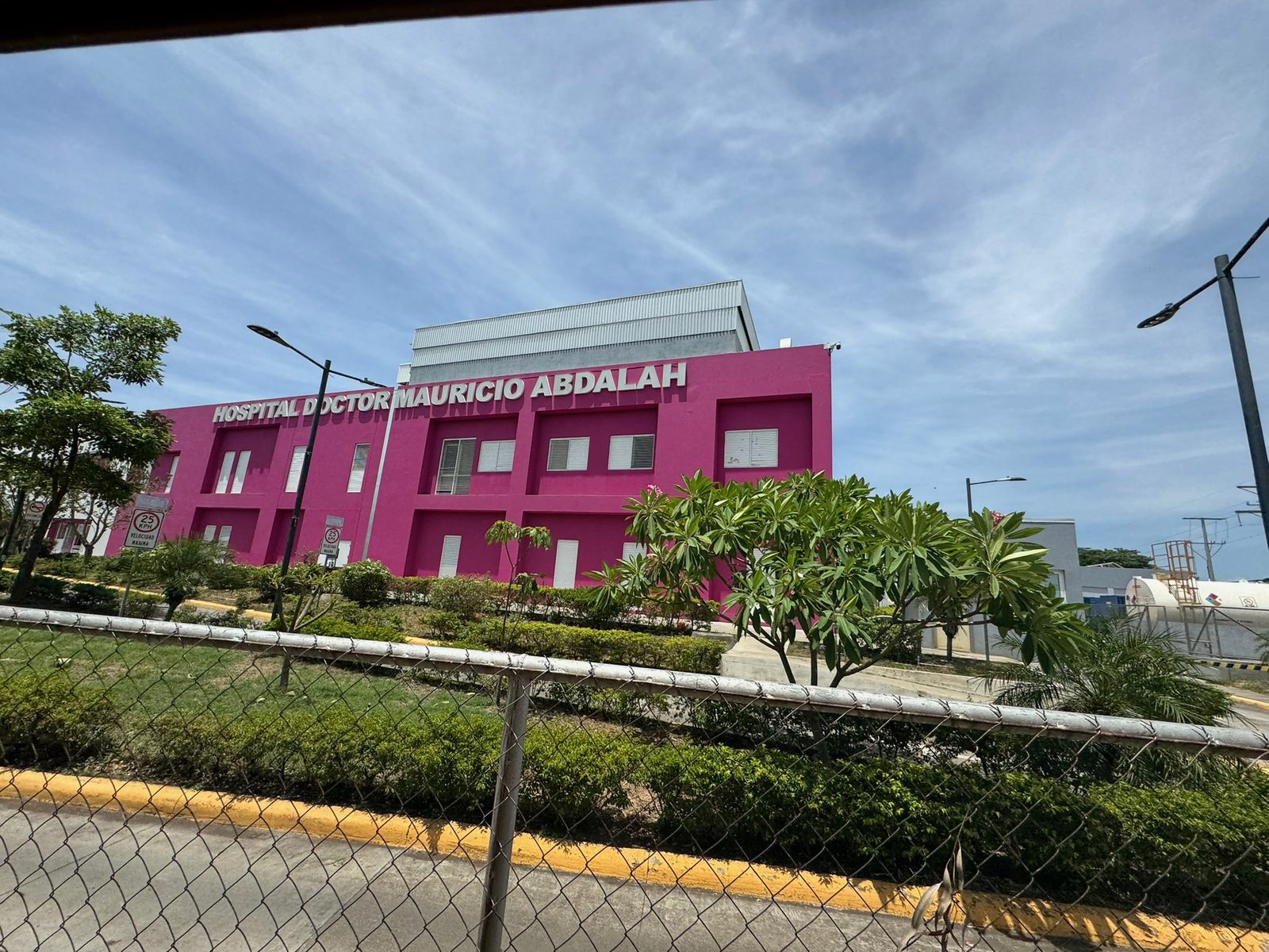 Magenta facade of Hospital Doctor Mauricio Abdalah behind a chain-link fence