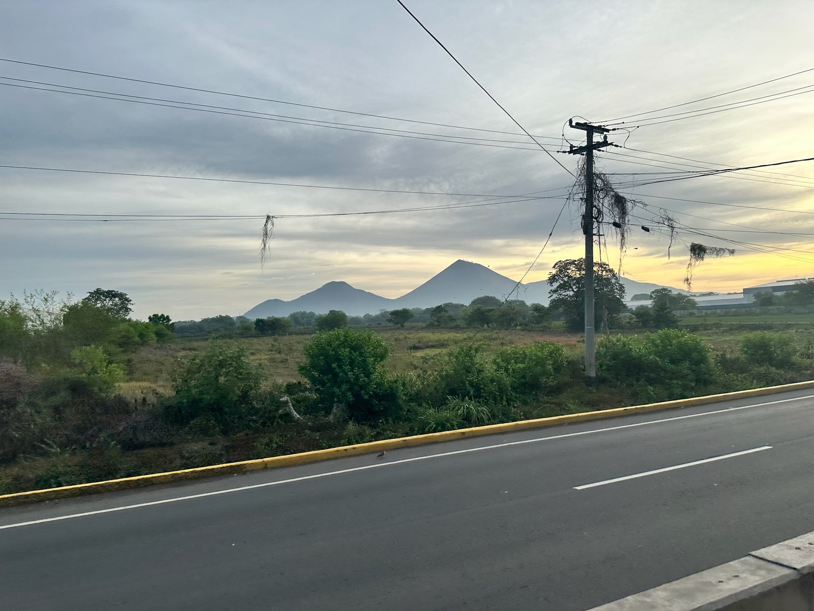Two volcanic cones on the Chinandega horizon beyond an empty road