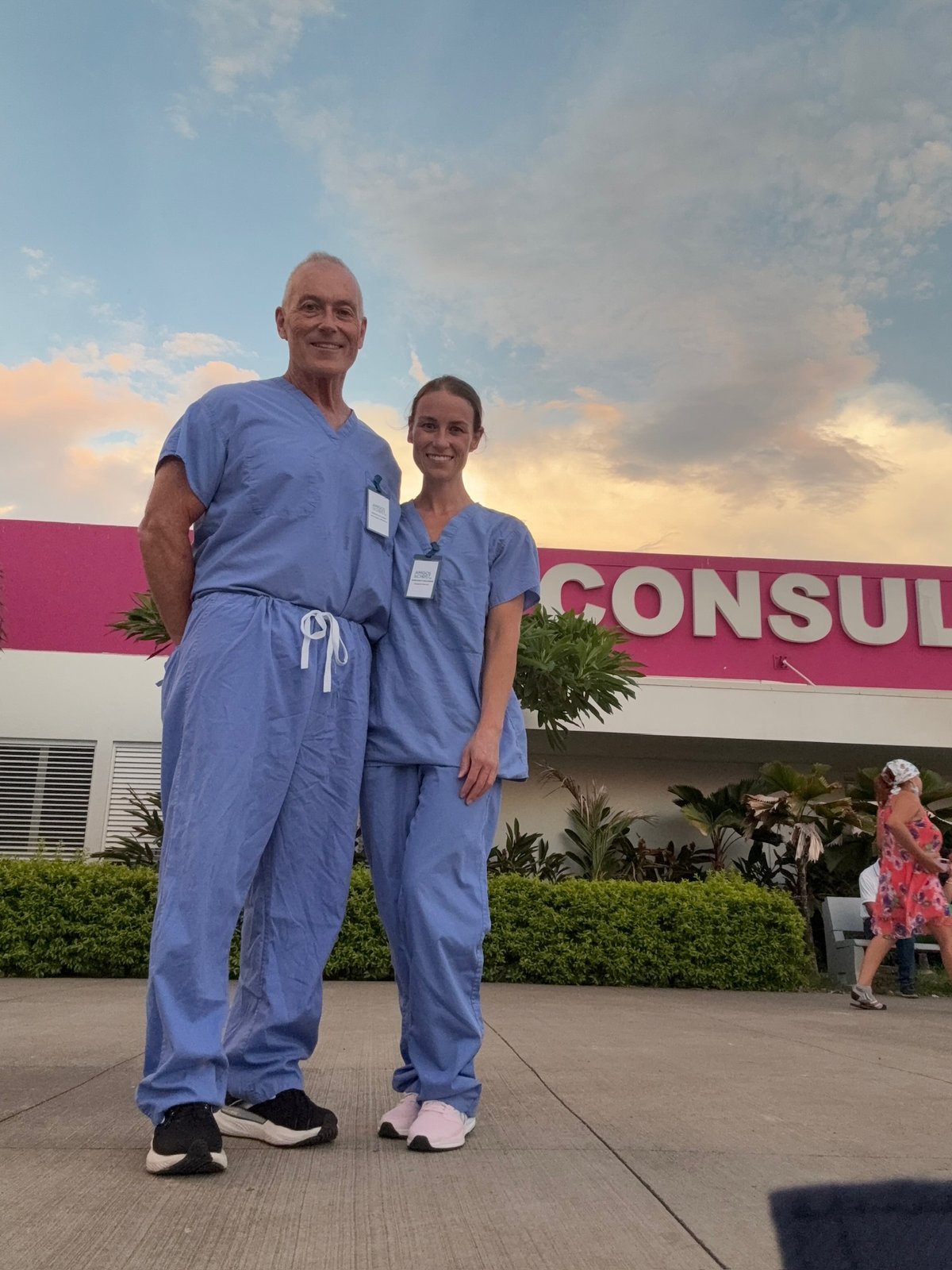Thomas James Gallagher and Margaret Eileen Gallagher in matching blue scrubs outside CONSULTA EXTERNA