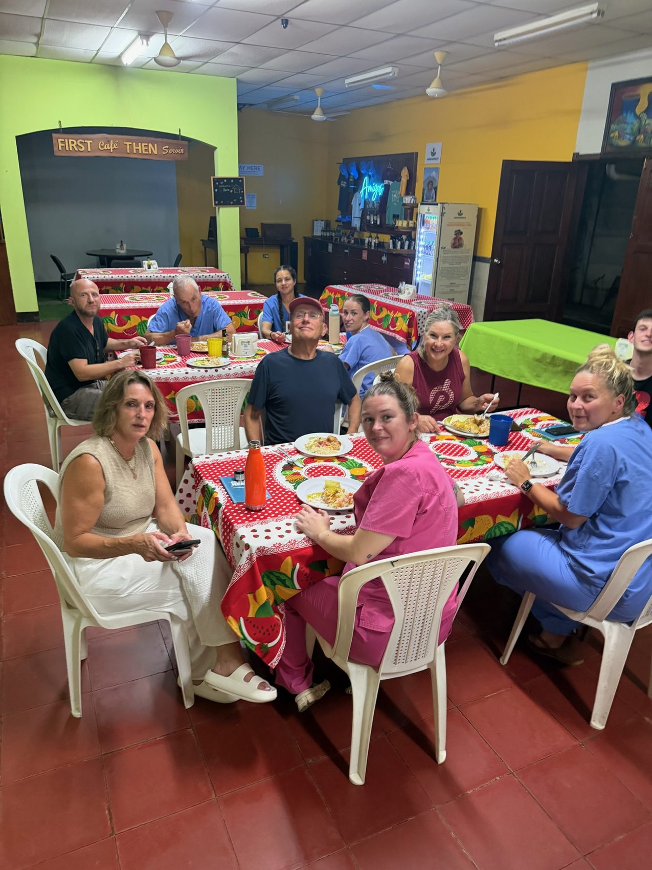 Team eating together at tables with red cloths in a Chinandega dining hall