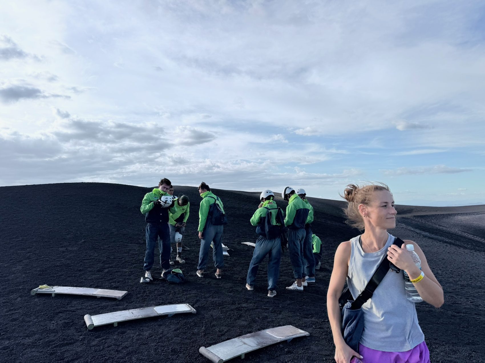 Team in green jackets with wooden volcano boards on black ash